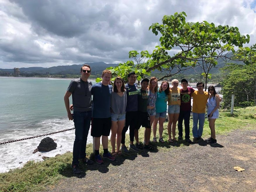 The 2019-20 GMI cohort stand in front of a white sand beach in Costa Rica.