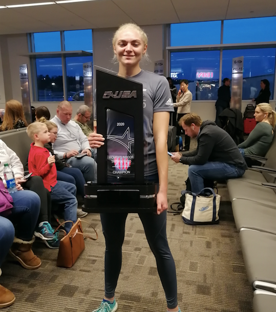 Hannah Jackson holding the C-USA indoor championship trophy at the before almost missing our flight