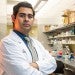 Mario Escobar in a lab dressed in a white lab coat
