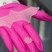 Pink gloved hand holds a wound healing patch